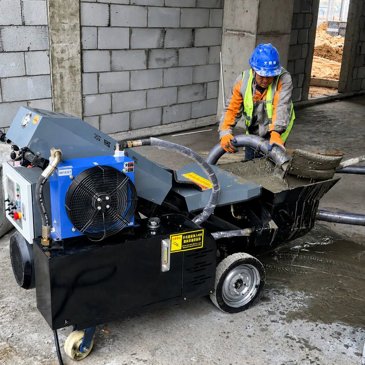 Worker feeding material into a concrete pump